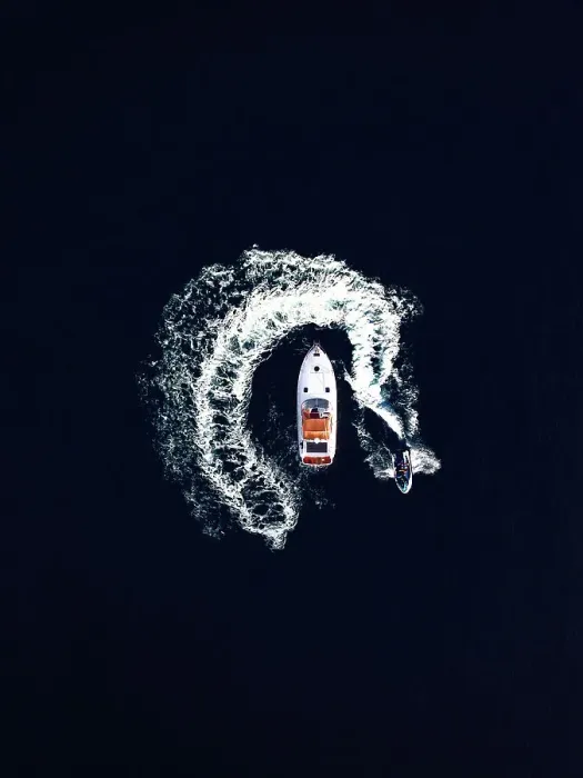 Framed Print : Aerial view of a jet ski swirling around a recreational boat