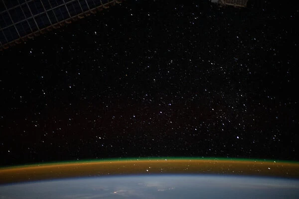 Airglow blankets the Earths horizon beneath a starry sky