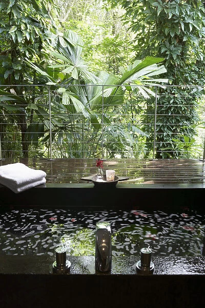 Bath on wooden terrace overlooking rainforest