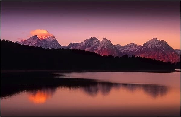 A beautiful coloured dawn casts its glow over Jackson lake in the Grand Tetons, Wyoming