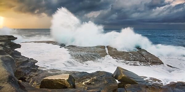 Big waves. Huge ocean waves crashing on rock shelf on cloudy stormy morning