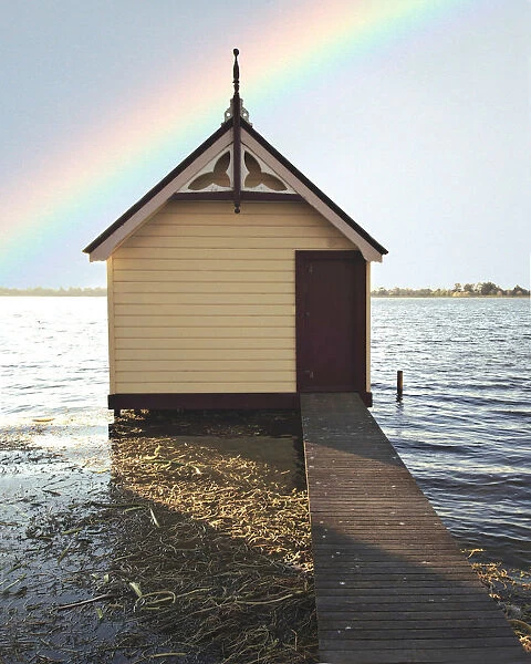Boat shed with rainbow in sky