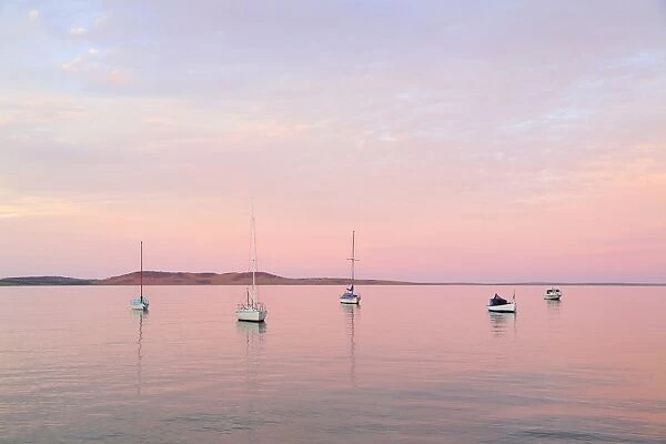 Boats moored in Boston Bay at sunset