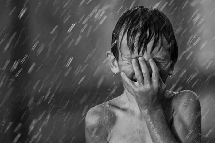 Framed Print : Boy playing in the sprinklers on a hot summer day