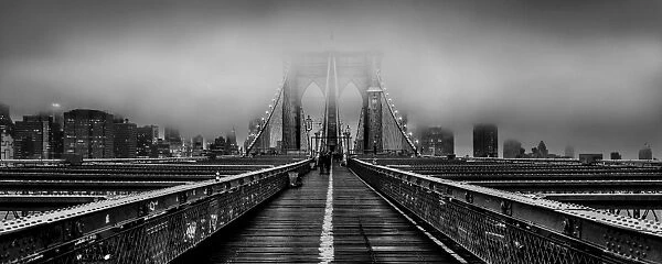 Brooklyn Bridge at dusk under a cloud of fog in black and white