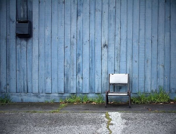 Chair in front of blue fence
