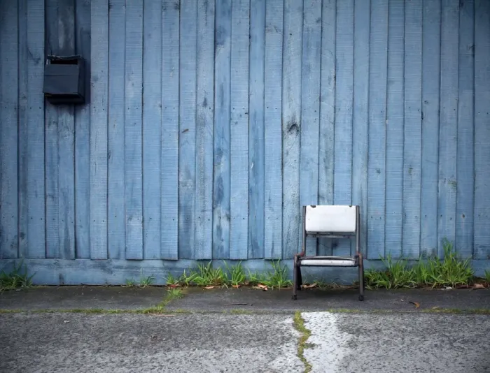 Framed Print : Chair in front of blue fence