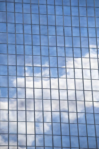 Clouds and sky reflected in mirrored windows of an office building