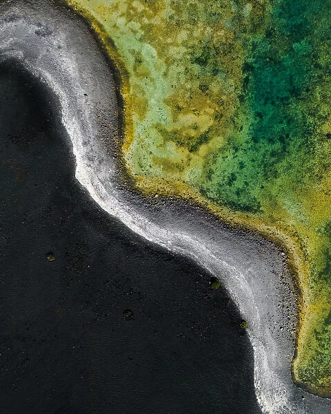 Contrast between volcanic sand and vibrant salt lake as seen from above, Lanzarote