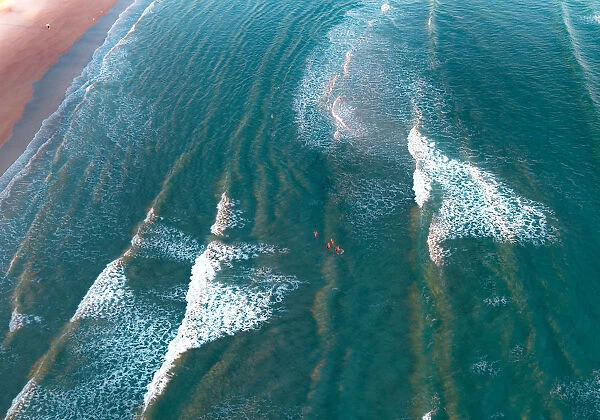 crystal clear waters with swimmers as seen from above