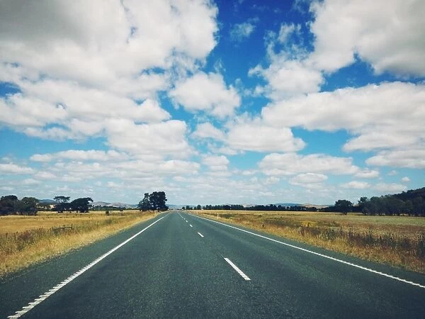 Dappled cloud over an empty highway