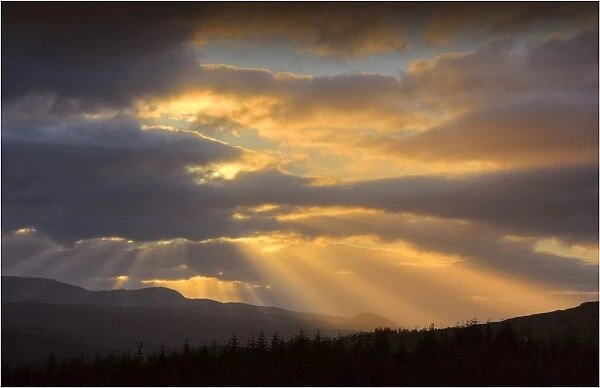 Dawn rays light up the sky over Loch Duich in the highlands of Scotland