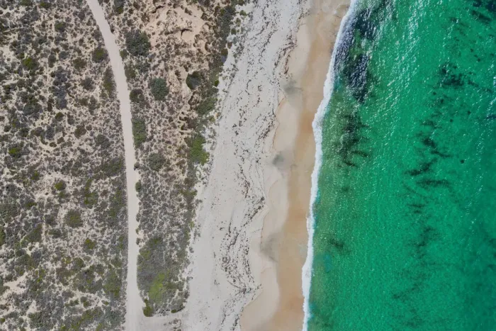Framed Print : Dirt road to a nice sandy beach - Aerial view
