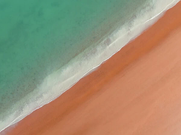 Drone shot looking down on calm waves washing onto Simpson Beach, Broome, Western Australia, Australia