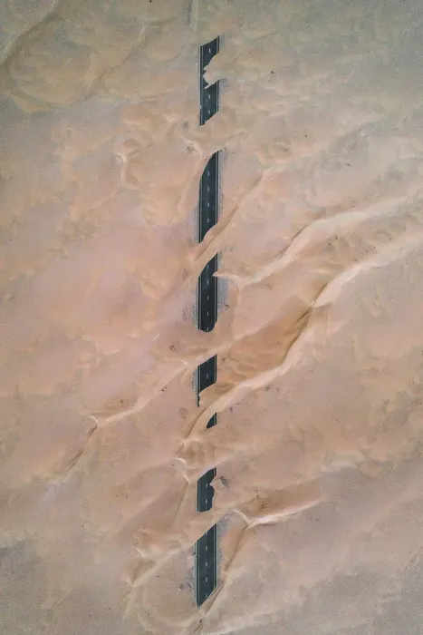 Framed Print : Dunes crossing a straight road in the desert, Dubai, United Arab Emirates