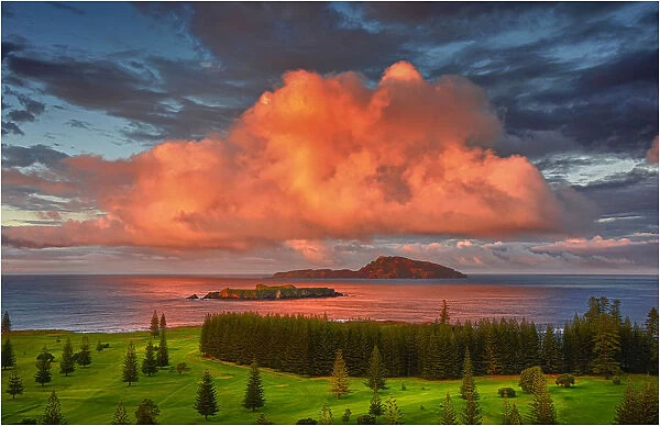 First light hits the coastal clouds and turns them a vivid pink at Slaughter bay, Norfolk Island