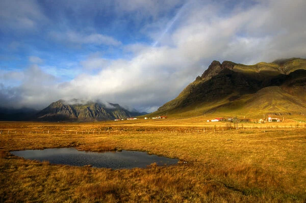 Icelandic houses rocky mountains and yellow grass