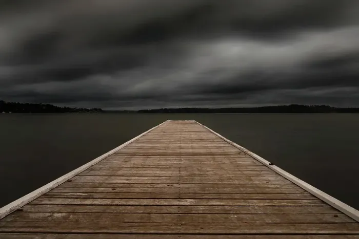 Framed Print : jetty out onto the lake with dark moody clouds