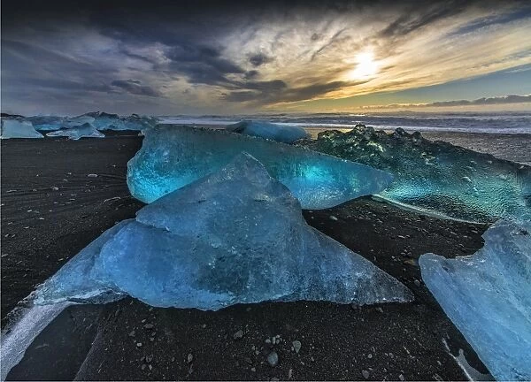 Jokulsarlon Beach in winter, just after a huge storm hit the coastline. Ice bergs from the nearby lagoon have been swept up onto the coastline and surge in and out with the tide