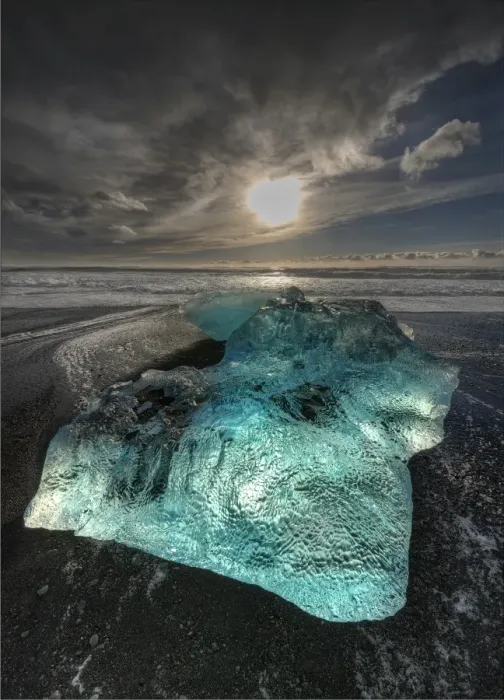 Framed Print : Jokulsarlon Beach in winter, just after a huge storm hit the coastline. Ice bergs from the nearby lagoon have been swept up onto the coastline and surge in and out with the tide