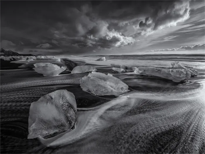 Framed Print : Jokulsarlon Beach in winter, just after a huge storm hit the coastline. Ice bergs from the nearby lagoon have been swept up onto the coastline and surge in and out with the tide