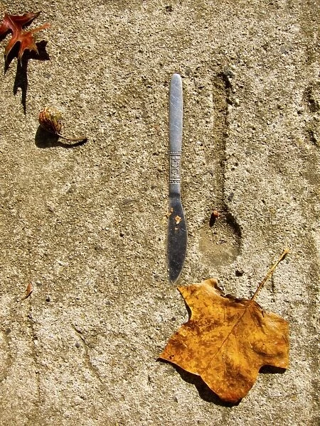 Knife embedded in concrete with spoon imprint