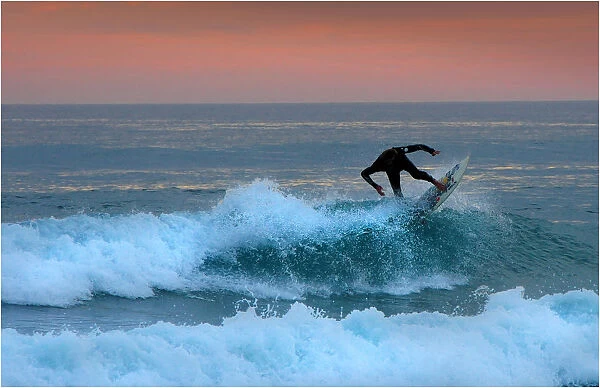A lone surfer rides a wave at Woolami Beach and coastline, Phillip Island, Victoria, Australia