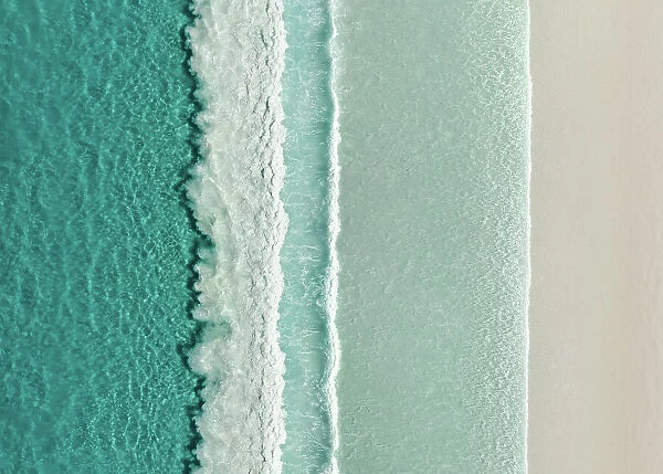 Majestic drone image looking down on rows of Ocean waves rolling onto an idyllic beach, Lucky Bay, Esperance, Western Australia, Australia
