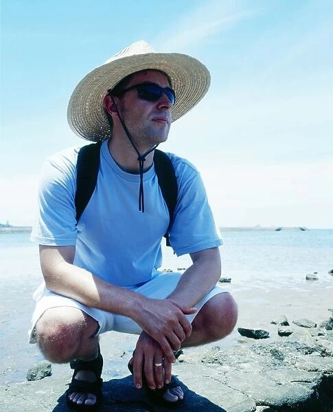 Man with sunhat on beach in Queensland, Australia