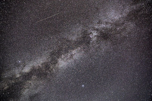 Milky Way. A Perseid meteor streaks across the sky, in parallel with the Milky Way