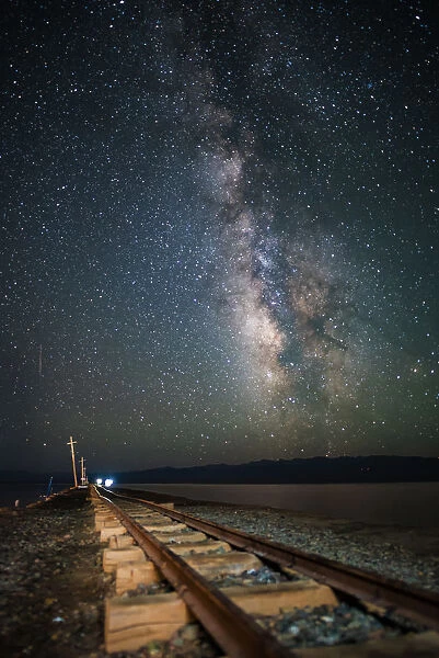 Milky way and mining railway track in Chaka Salt Lake on Qinghai-Tibetan Plateau, China