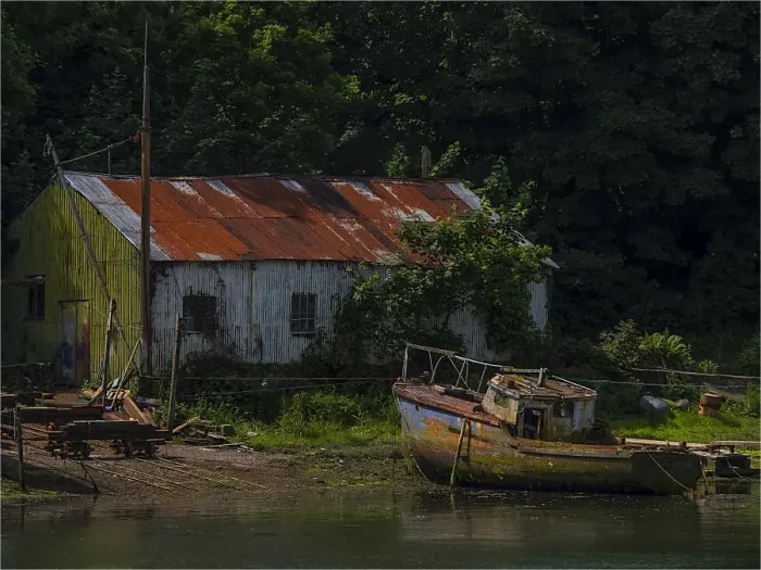 Framed Print : Old boatshed and derelict fishing boat moored on the river at Caernarfon, Northern Wales, United kingdom