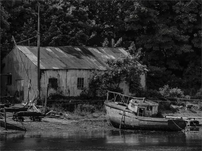 Framed Print : Old boatshed and derelict fishing boat moored on the river at Caernarfon, Northern Wales, United kingdom