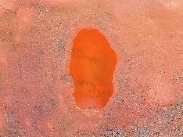 Oval shaped pool of water in an iron mine shot from a drone perspective, Western Australia, Australia