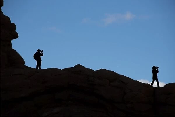 Photographers silhouretted against the sky in the Arches national park, Utah, USA