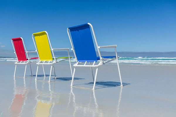 Red, blue and yellow beach chairs. Australia