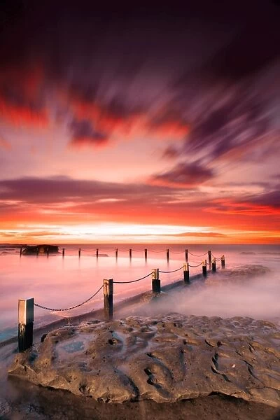 Red dawn. Colorful sunrise over Mahon Pool at Maroubra Beach, Syndey, NSW, Australia