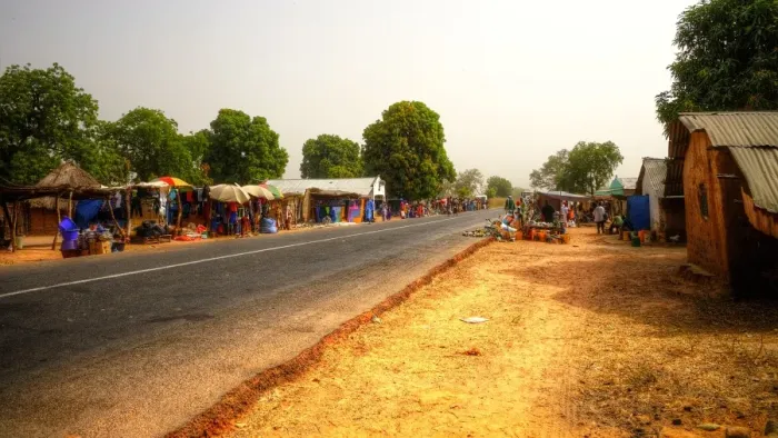 Framed Print : Road market in rural Gambia with colourful stalls, clear sky and no cars Framed Print : Road market in rural Gambia with colourful stalls, clear sky and no cars