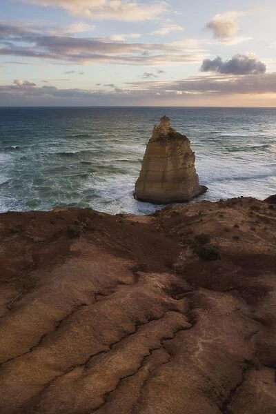 A sea stack below an eroding cliff edge at sunset, Great Ocean Road, Victoria, Australia