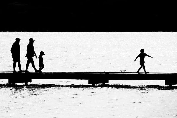 Silhouettes of people on a wharf