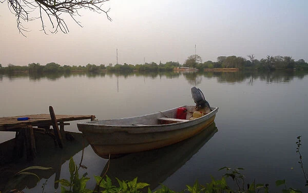 Small Fishing boat on banks of river Gambia in early morning before sunrise