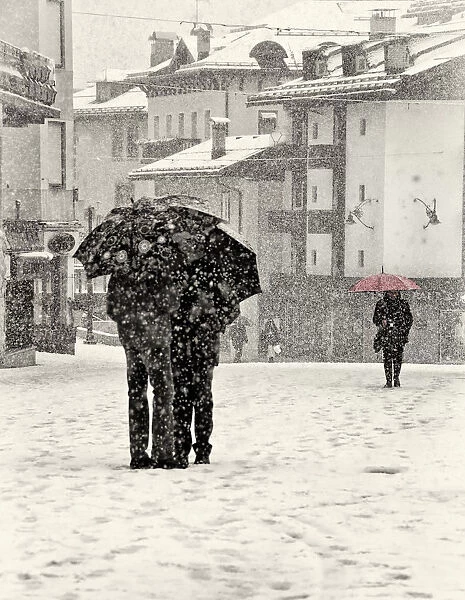 Snow talk. A lady with a red umbrella walking in heavy snowfall