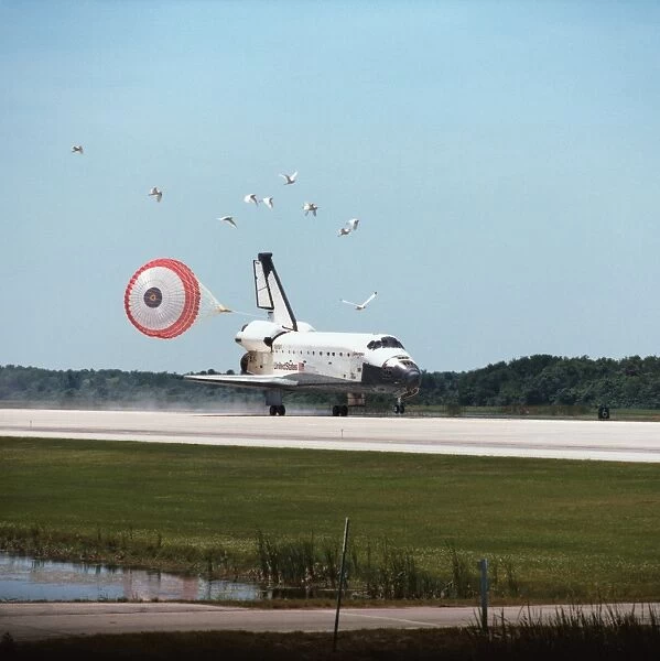 The space shuttle landing with its drogue parachute deployed