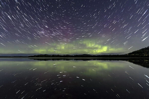 Star trails and the Aurora Australis or Southern Lights reflected in water