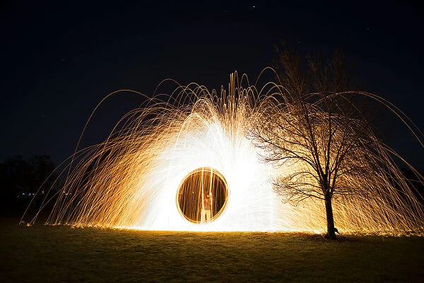 Steel wool spinning near tree at night