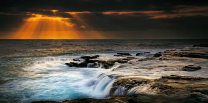 Framed Print : Sunbeams over stormy sea