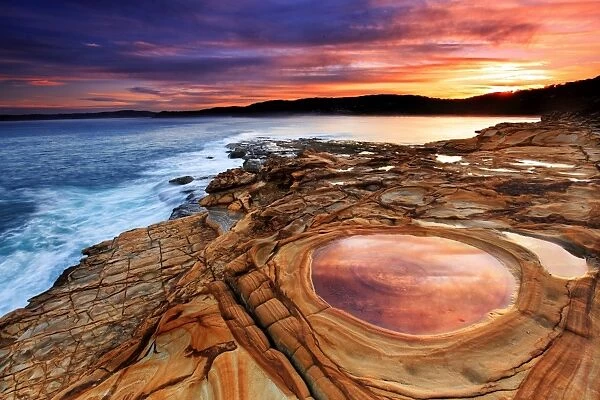Sunset over rock formation and sea