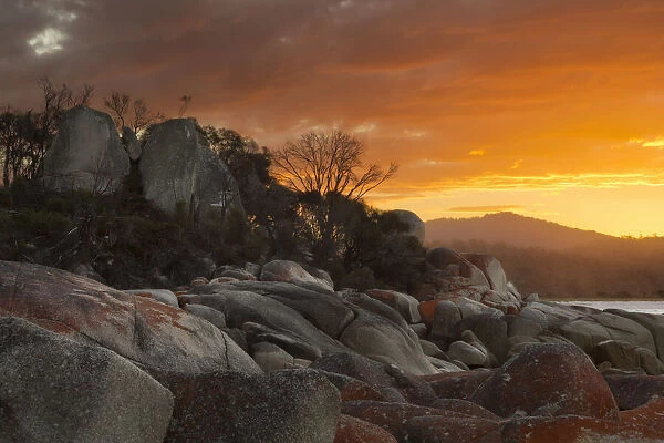 Sunset over a rocky shoreline, Bay of Fires, Tasmania, Australia