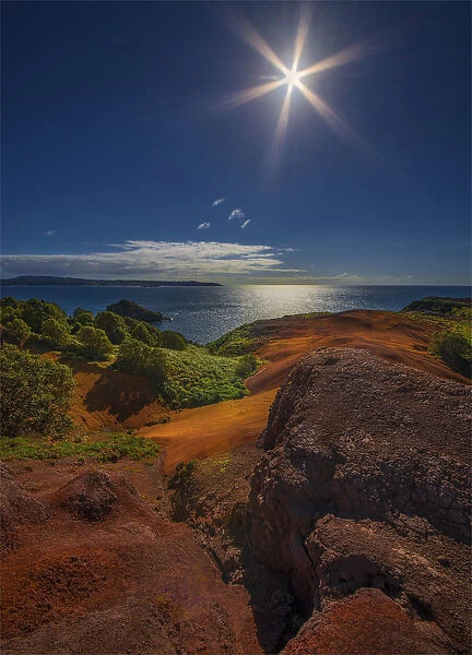 Sunstar over the coastline on Phillip Island, a small islet near Norfolk Island
