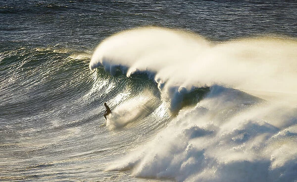 surfing down the face of a big wave